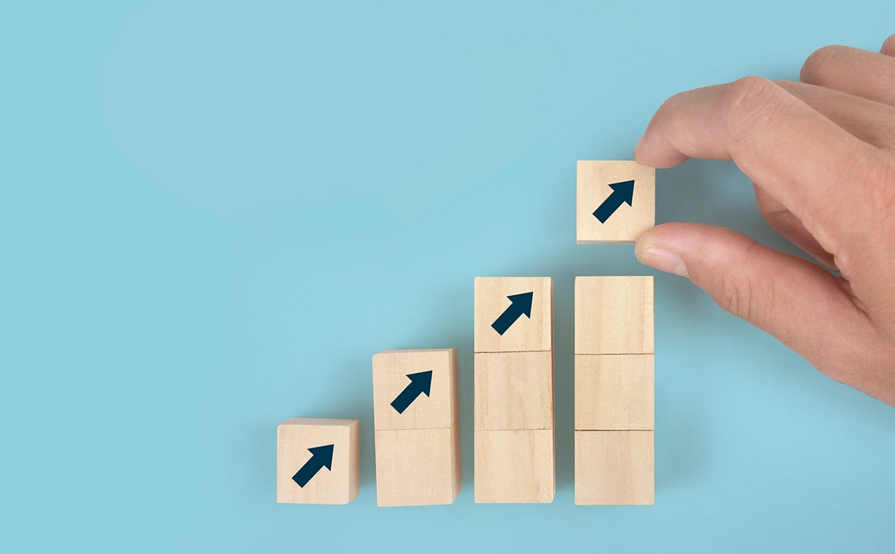 Wooden cubes with upward arrows indicating an increase or growth